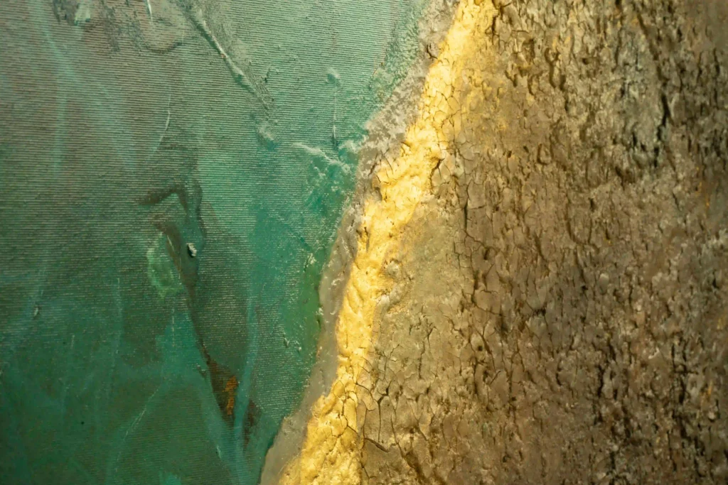 Detailaufnahme abstrakter Acrylkunst mit goldener Struktur und türkisfarbener Oberfläche.